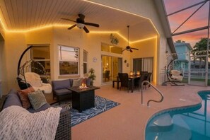 Ein gemütlicher Außenbereich mit Pool, Sitzgelegenheiten und Deckenventilatoren.