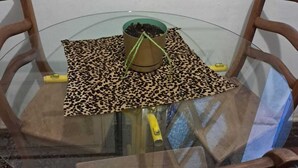 A round glass table with a leopard print placemat, a small plant, and a yellow object on it. - Apartamento Simples mas Completo Centro Histórico Área Tranquila (Porto Alegre)