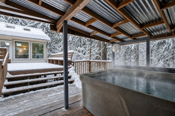 Ein Whirlpoolbereich mit Holzterrasse und überdachter Sitzgelegenheit.