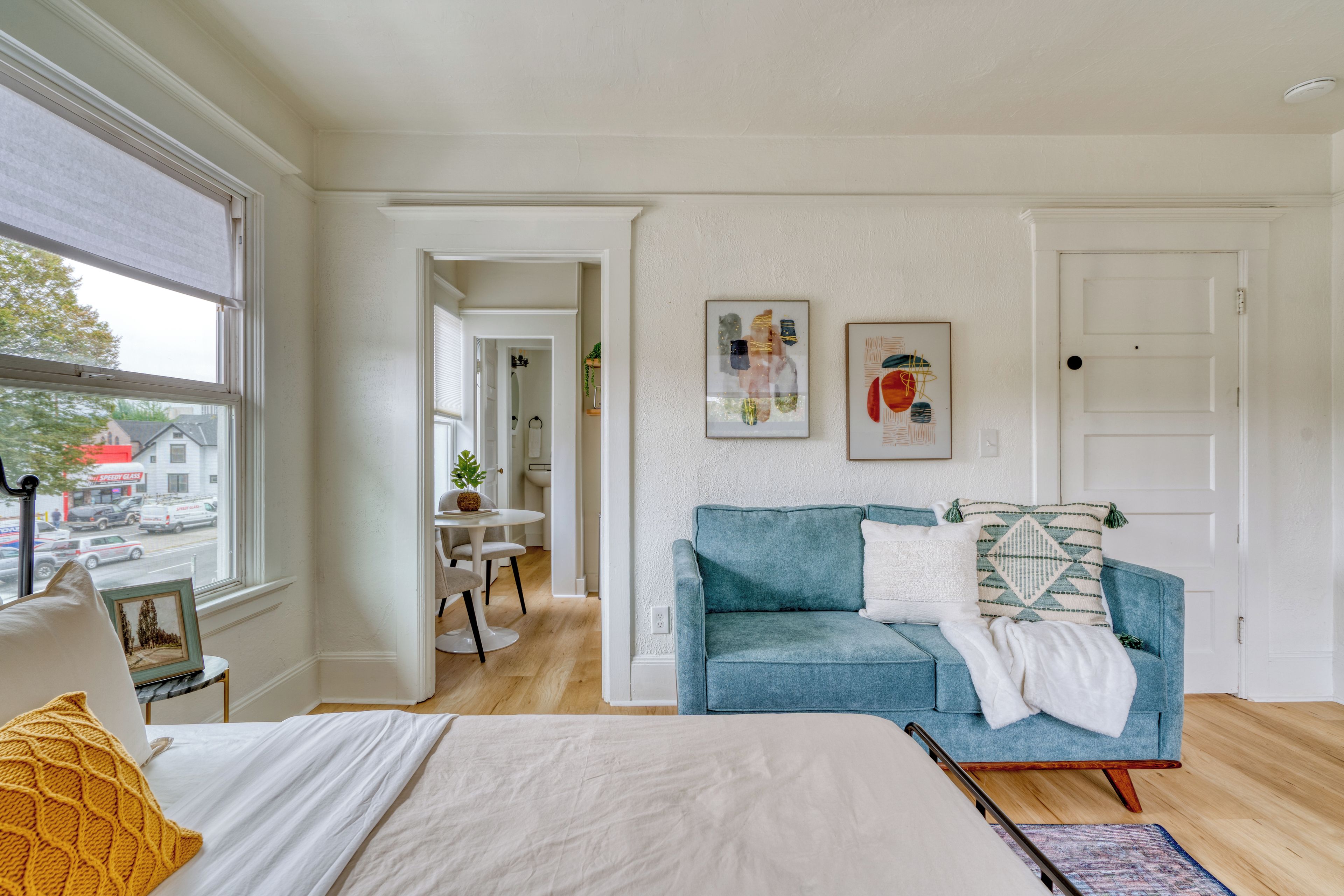 Ein Schlafzimmer mit einem Bett, einem blauen Sofa und einem Fenster.