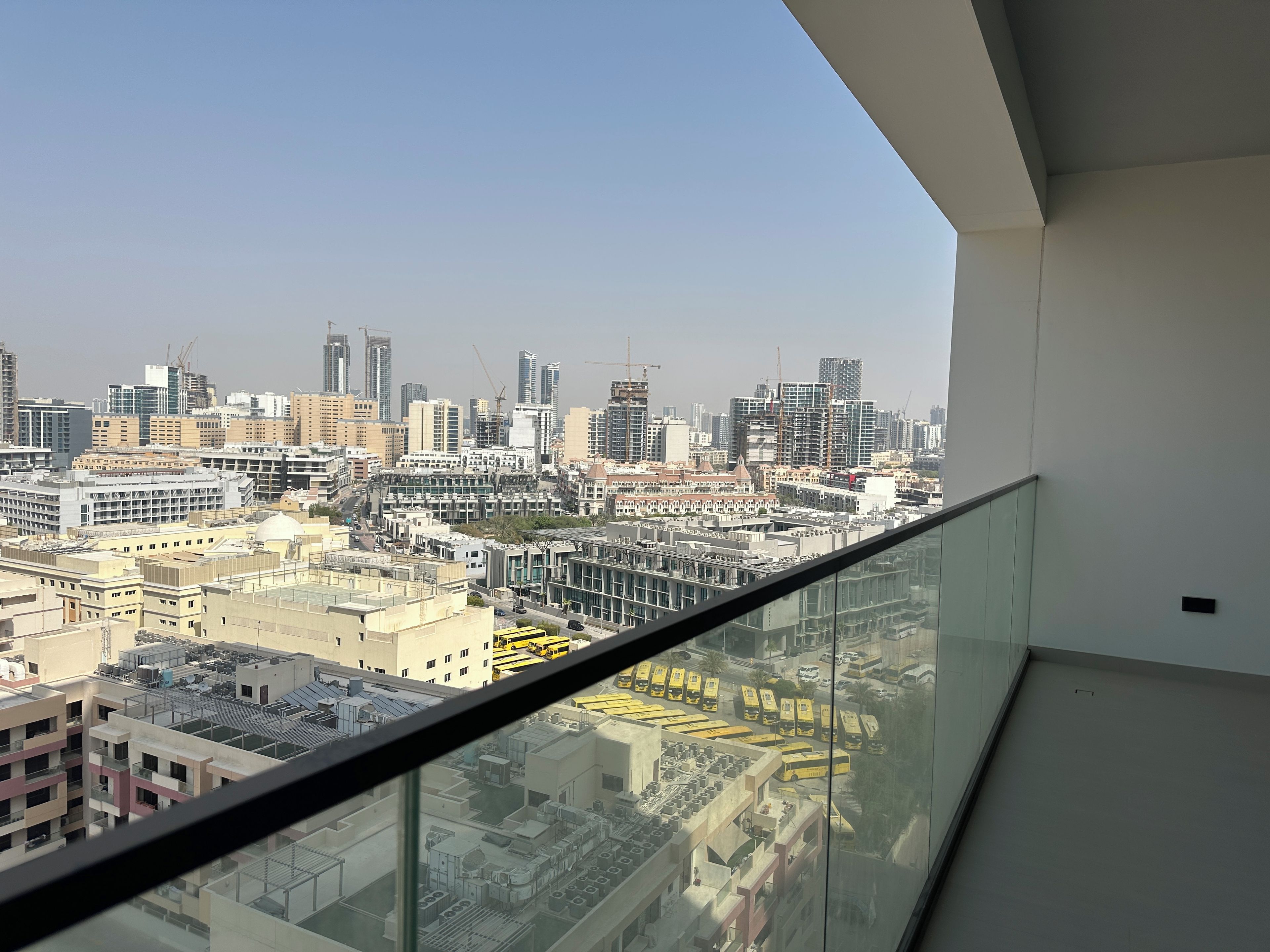 A high-rise building with a glass balcony overlooking a cityscape.