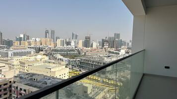 A high-rise building with a glass balcony overlooking a cityscape.
