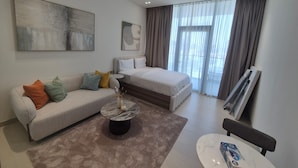 Et moderne hotelværelse med seng, sofa, sofabord og billedkunst på væggene.