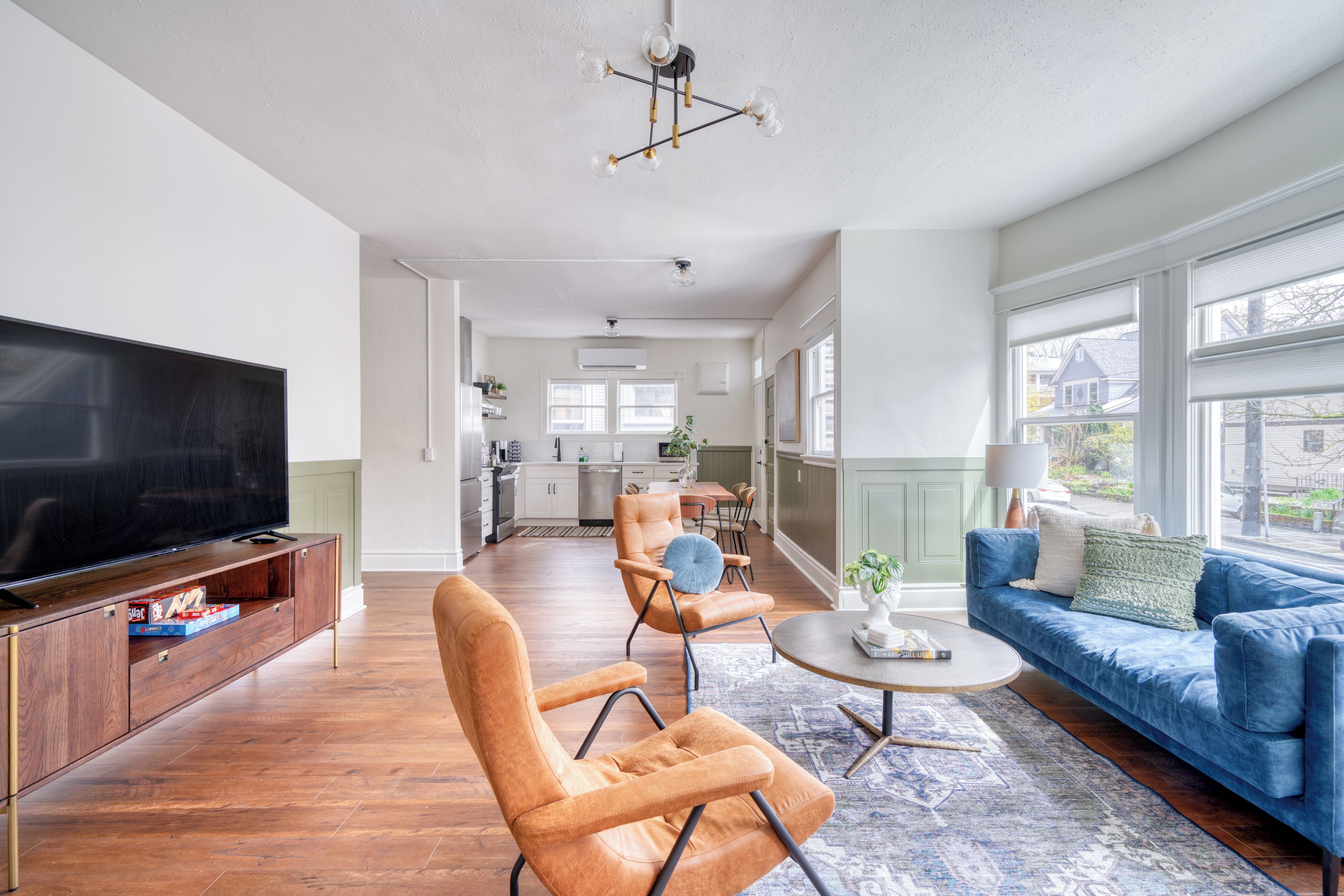 Ein modernes Wohnzimmer mit Flachbildfernseher, einem blauen Sofa und einem Couchtisch.