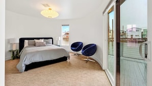 A modern bedroom with a bed, bedside tables, a lamp, and a view of the outside. - Aqua Star - Iconic Floating Home, Seen on HGTV (Portland)