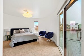 A modern bedroom with a bed, bedside tables, a lamp, and a view of the outside. - Aqua Star - Iconic Floating Home, Seen on HGTV (Portland)