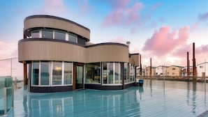 A modern multi-level building with large windows and a pool area. - Aqua Star - Iconic Floating Home, Seen on HGTV (Portland)