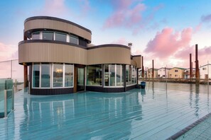 A modern multi-level building with large windows and a pool area. - Aqua Star - Iconic Floating Home, Seen on HGTV (Portland)