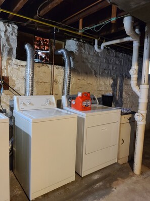 A laundry room with two washing machines, a dryer, and a water heater. - A Travel Nurse's Cozy Bird's Nest 1B1B Apartment (St. Louis)