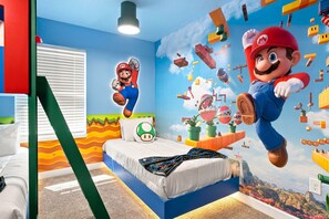 A bedroom with a bed, a pillow, and a wall mural of a video game character. - Chic Disney Retreat with Fun Themed Rooms (Kissimmee)