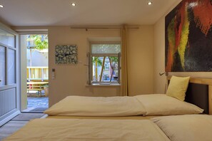 Un dormitorio con cama, ventana y un cuadro en la pared.