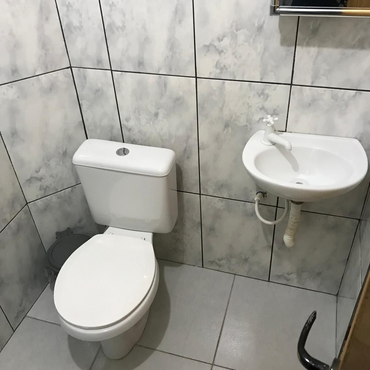 A bathroom with a toilet and a sink.