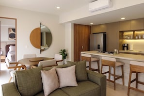 A modern kitchen with a central island, wooden cabinets, and a built-in refrigerator. - Zapopan apartment with pool and gym (Zapopan)