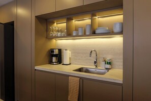 A modern kitchen with a built-in sink, a coffee maker, and a towel hanging on the door. - Zapopan apartment with pool and gym (Zapopan)