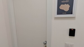 Eine geschlossene Tür mit einem Schlüsselfeld und einer Karte von Molara im Rahmen an der Wand.