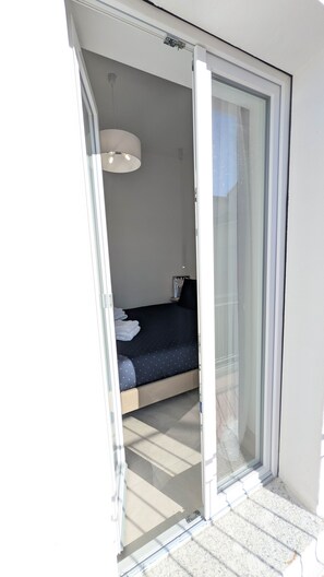 A room with a bed, a nightstand, and a wall-mounted lamp. - Molara - Comfort Double Room (Olbia)