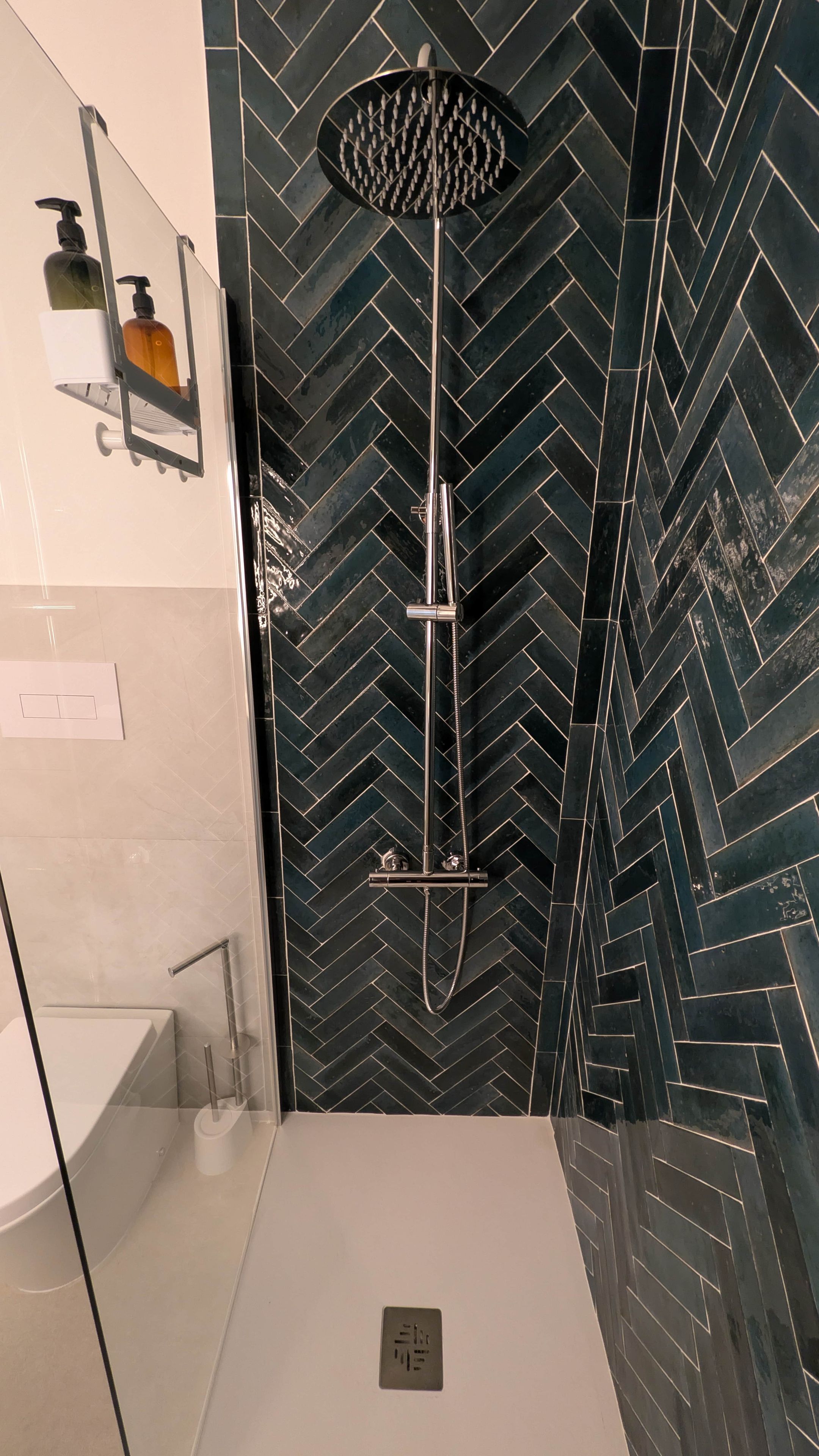 Ein modernes Badezimmer mit Dusche, Handtrockner und Seifenspender.