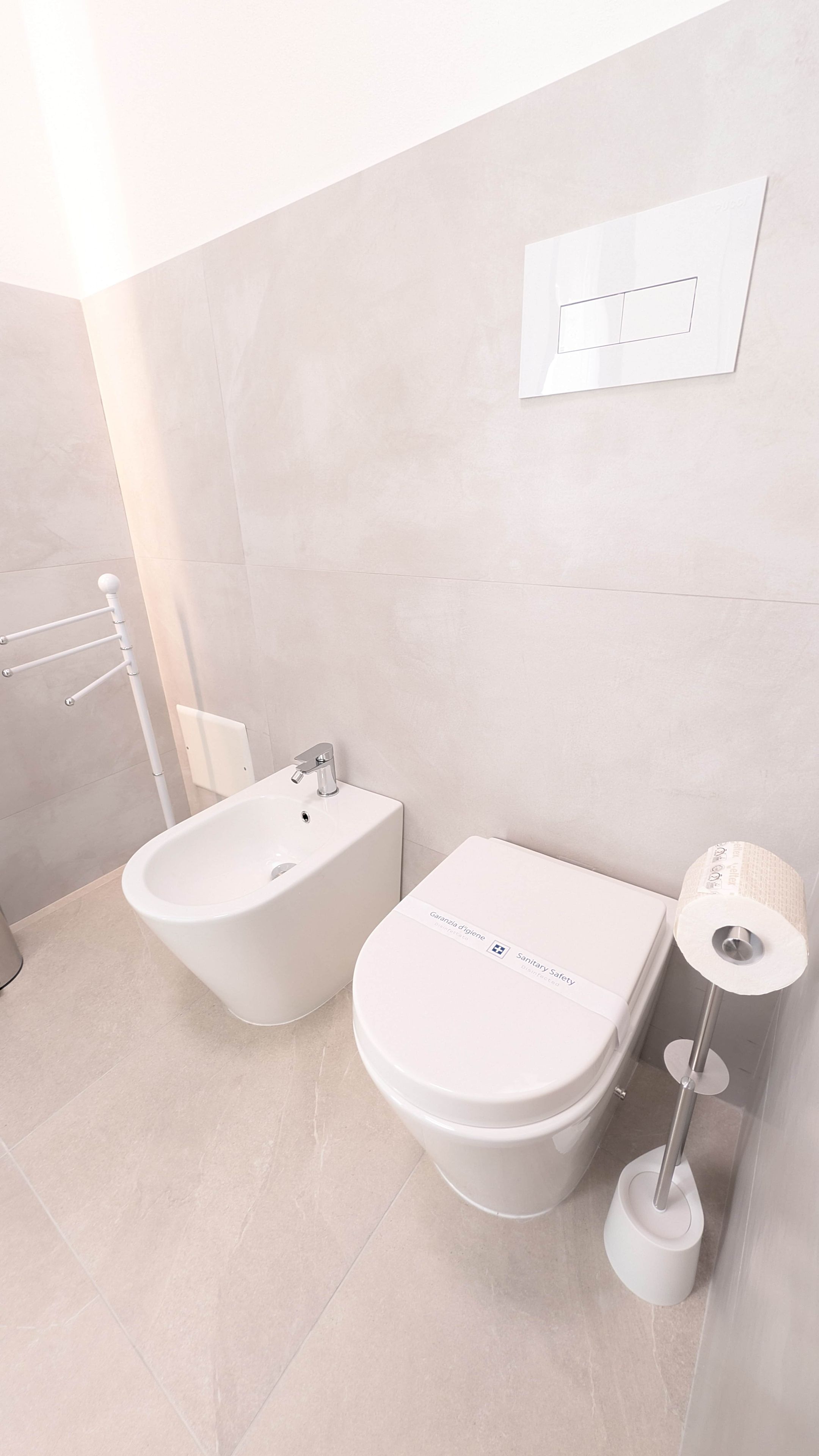 Un baño moderno con un bidé, inodoro y un secador de manos.