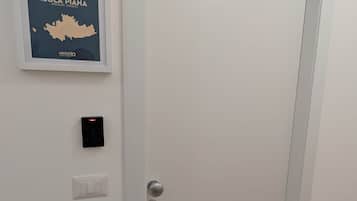 Eine geschlossene Tür mit einem Schlüsselfeld und einem Lichtschalter an der Wand.