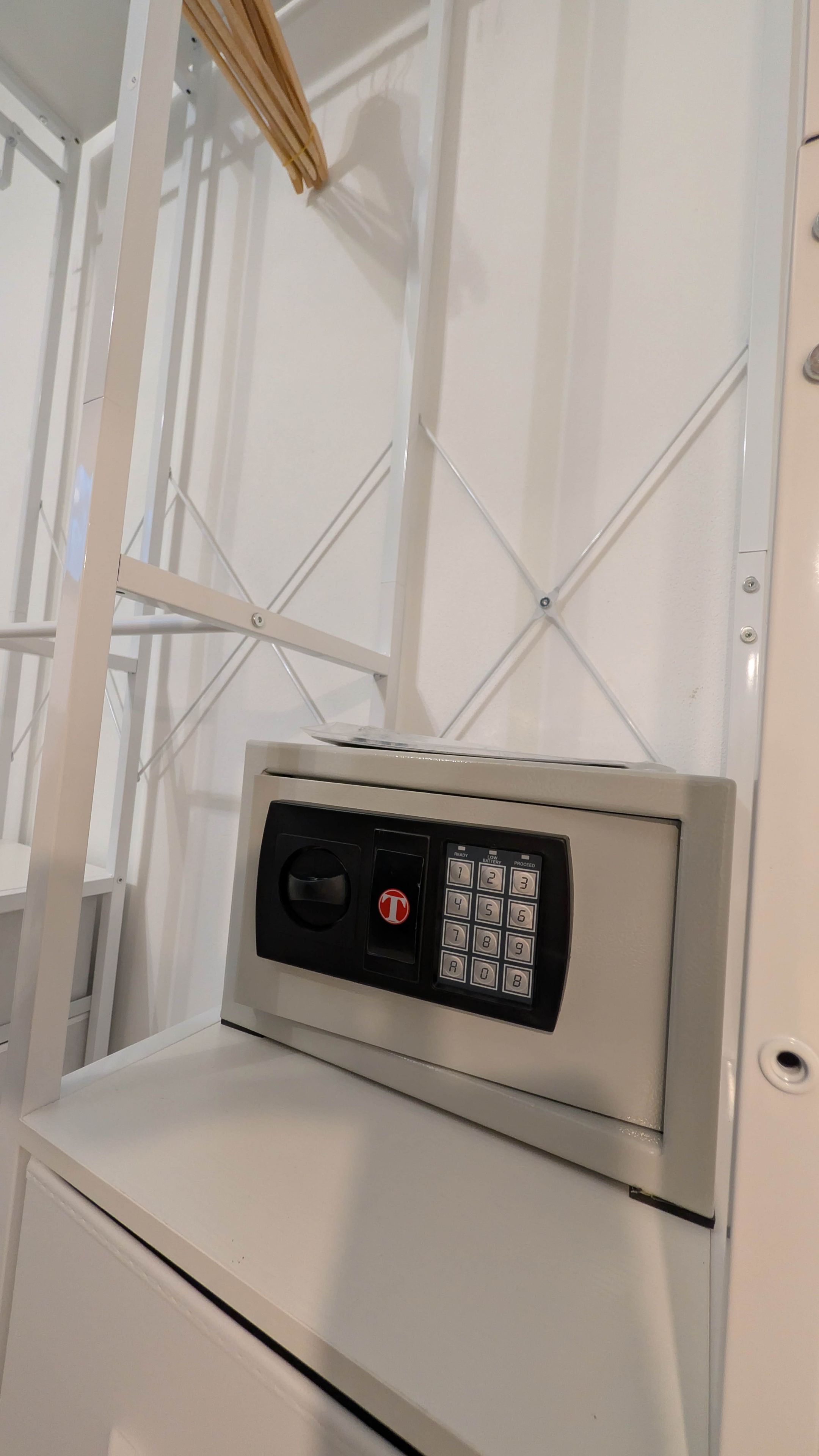 Une porte blanche dotée d’un clavier à code, avec un cadre en métal et une fenêtre au-dessus.