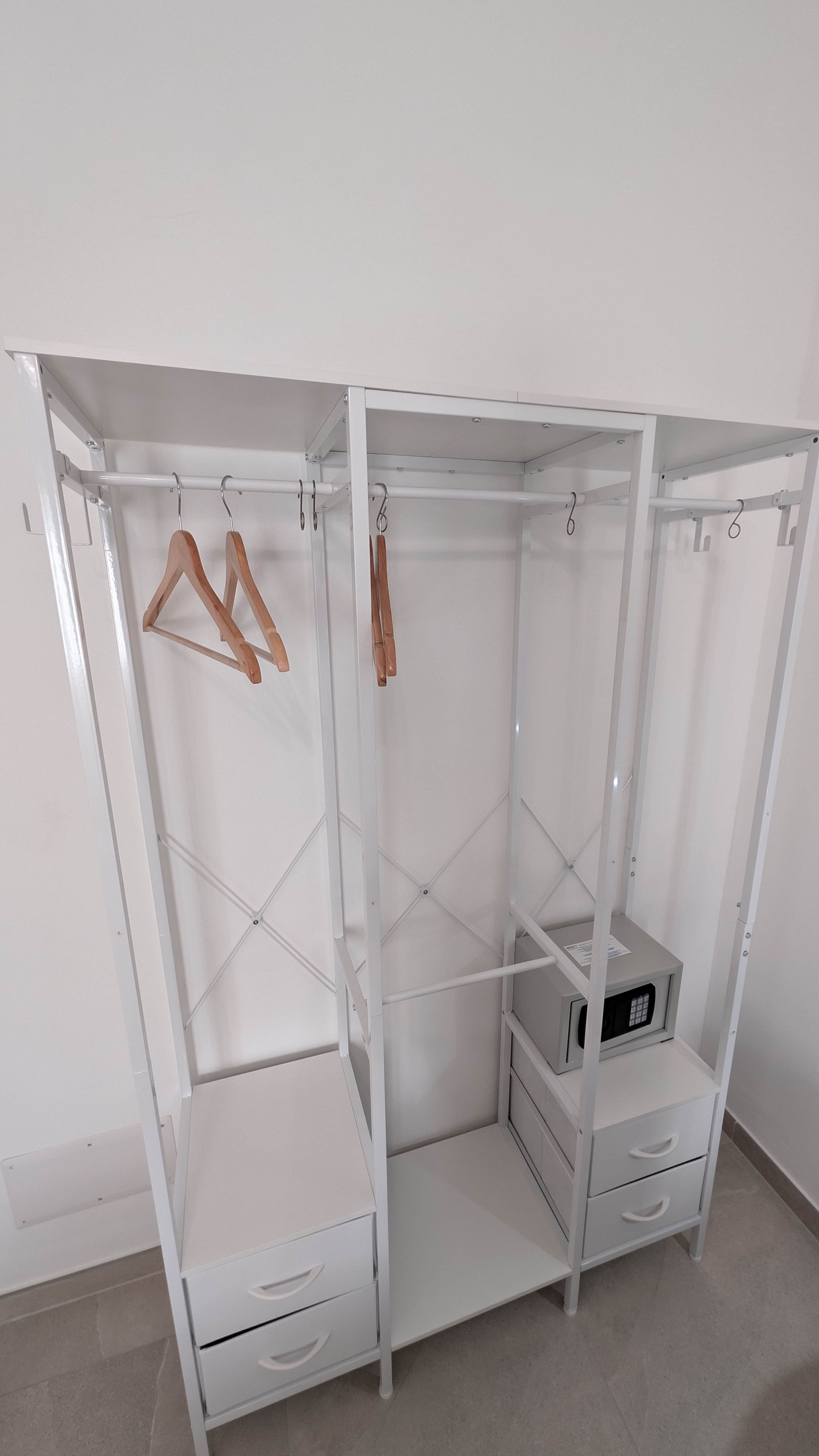 A white wardrobe with multiple shelves, drawers, and hanging space.
