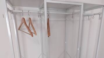 A white wardrobe with multiple shelves, drawers, and hanging space.
