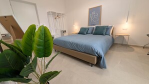 Un dormitorio con cama, mesitas de noche, armario y un cartel en la pared.