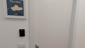 Puerta cerrada con teclado de seguridad e interruptor de luz en la pared.
