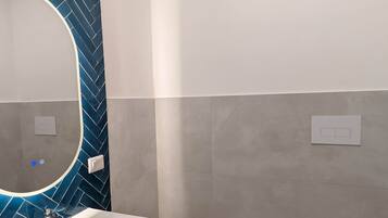 Ein modernes Badezimmer mit einem weißen Waschtisch, einem Bidet und einer Toilette.