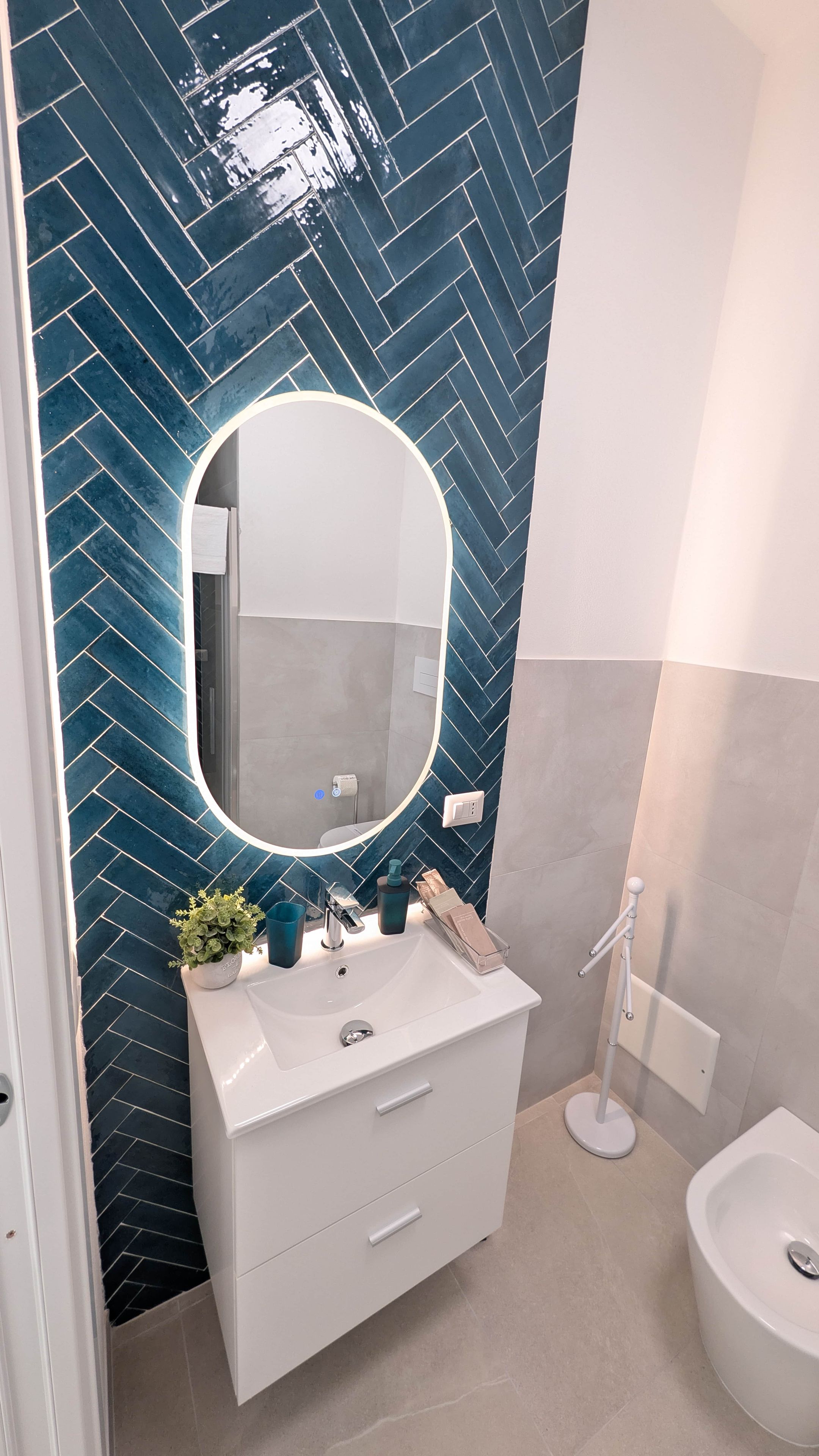 A bathroom with a white vanity, a mirror, and a sink.