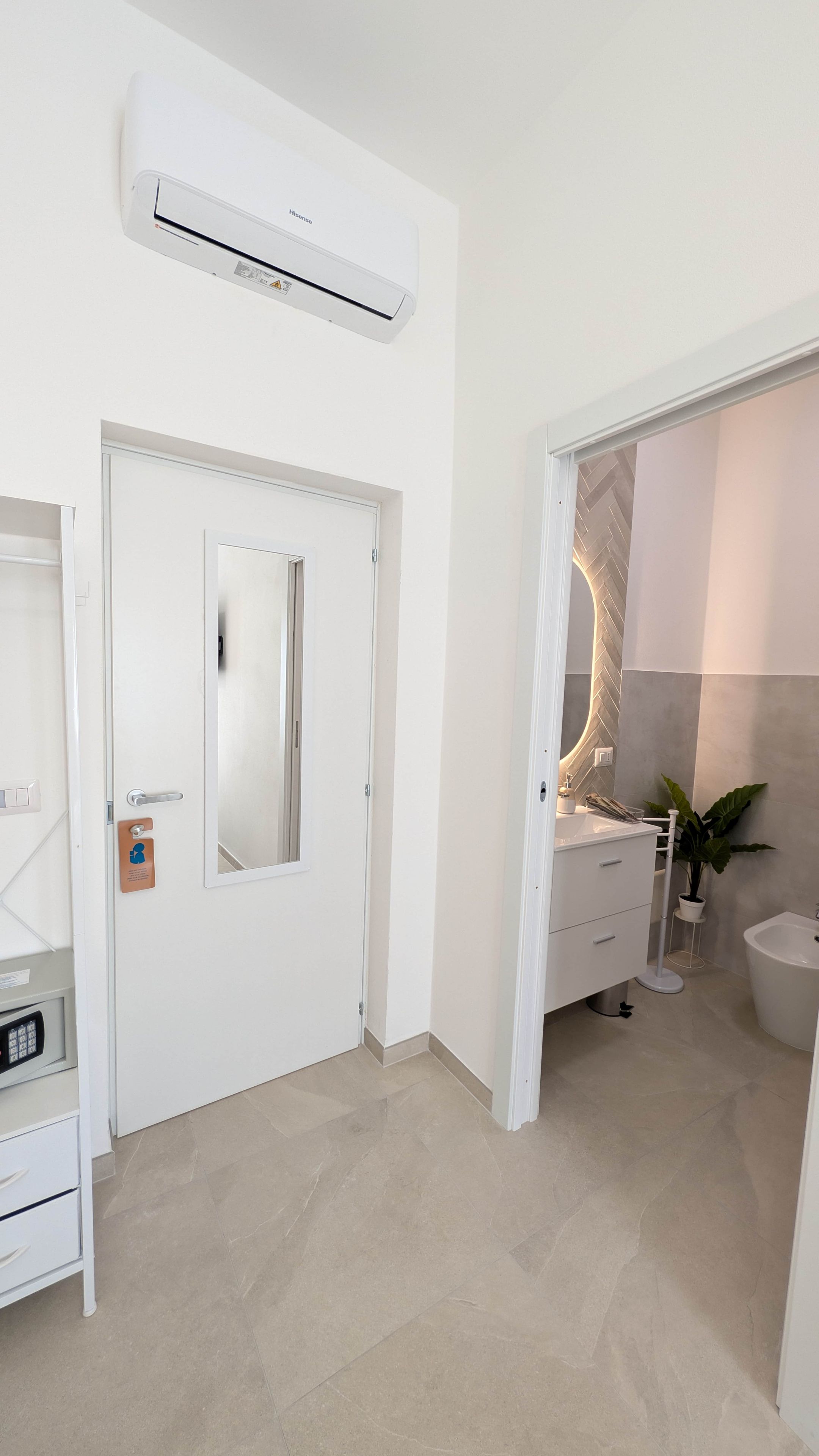 A modern bathroom with a white sink, a mirror, and a toilet.