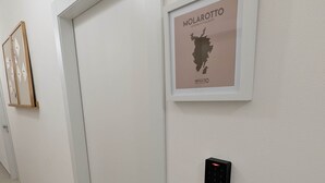 Un couloir avec une carte encadrée de Molarotto, une porte et un appareil fixé au mur.