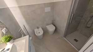 Un baño moderno con ducha, inodoro, bidé y una pequeña planta en maceta.