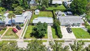 An aerial view of a residential area with houses, a driveway, and parked cars. - Charming 2-Bedroom Home Near Siesta Key, Sleeps 6 (Sarasota)
