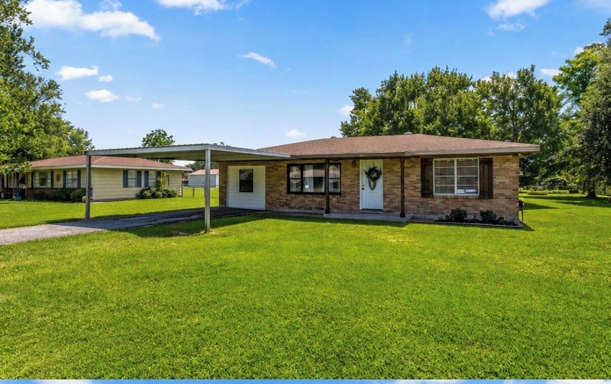 A single-story house with a brick facade, a front porch, and a well-maintained lawn.