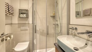 A modern bathroom with a glass-enclosed shower, a white toilet, and a large sink with a marble countertop. - Maisonette Apartment The Haystack Ad1716 (Marktheidenfeld)