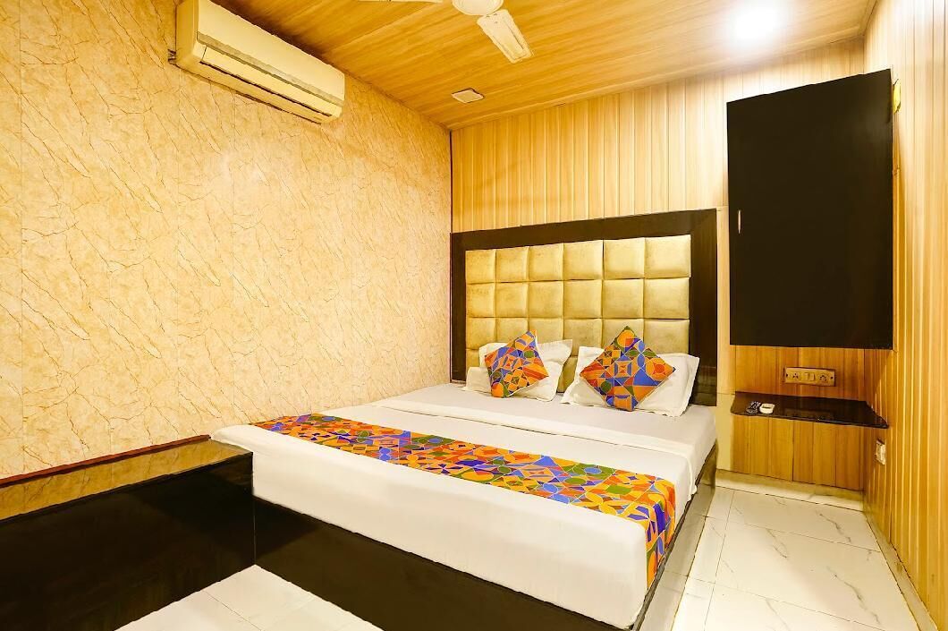 Une chambre d’hôtel avec un lit, une télévision et un plafond en bois.