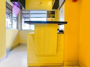 Un pasillo estrecho con un mostrador amarillo y una ventana.