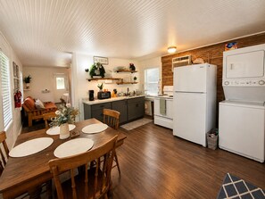 Eine kleine Küche mit Essbereich, Holzböden und einem weißen Kühlschrank.