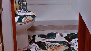 A bathroom with a shower, toilet, and a towel rack. - Luxury loft at 63rd on Oxford Street (Accra)