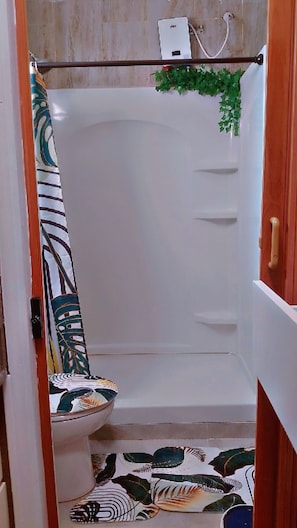 Ein Badezimmer mit Dusche, Toilette und Handtuchhalter.