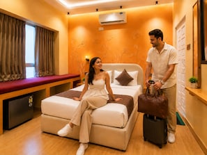 A hotel room with a bed, a bench, an air conditioning unit, and a wall-mounted plant. - White Nest Udaipur - Stay Above the City of Lakes, Old City (Udaipur)