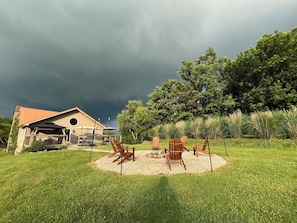 Et hus med en overdækket terrasse, udendørs møbler og udsigt til et skovområde.