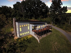 Ein modernes Haus mit einer Terrasse, umgeben von Bäumen.