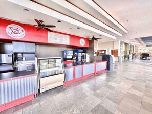 A food counter with a menu board, a Pepsi refrigerator, and a glass display case. - Cozy Studio w/ Pool View  2 Queens & Patio Dining (Honolulu)