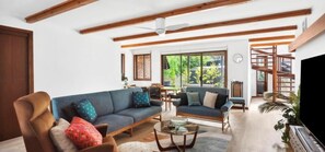 A living room with a sofa, armchair, and coffee table. There is a TV on the right. - Family-Friendly Renovated 4BR Clifton Retreat (Greater Geelong)