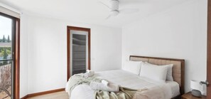 A bedroom with a bed, a bedside table, a nightstand, a window, and a door. - Family-Friendly Renovated 4BR Clifton Retreat (Greater Geelong)