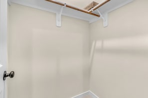 Eine Ecke eines Raumes mit einer weißen Tür und einem Holzbalkenbau an der Decke.