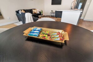 Een eettafel met een dienblad vol verschillende snacks.