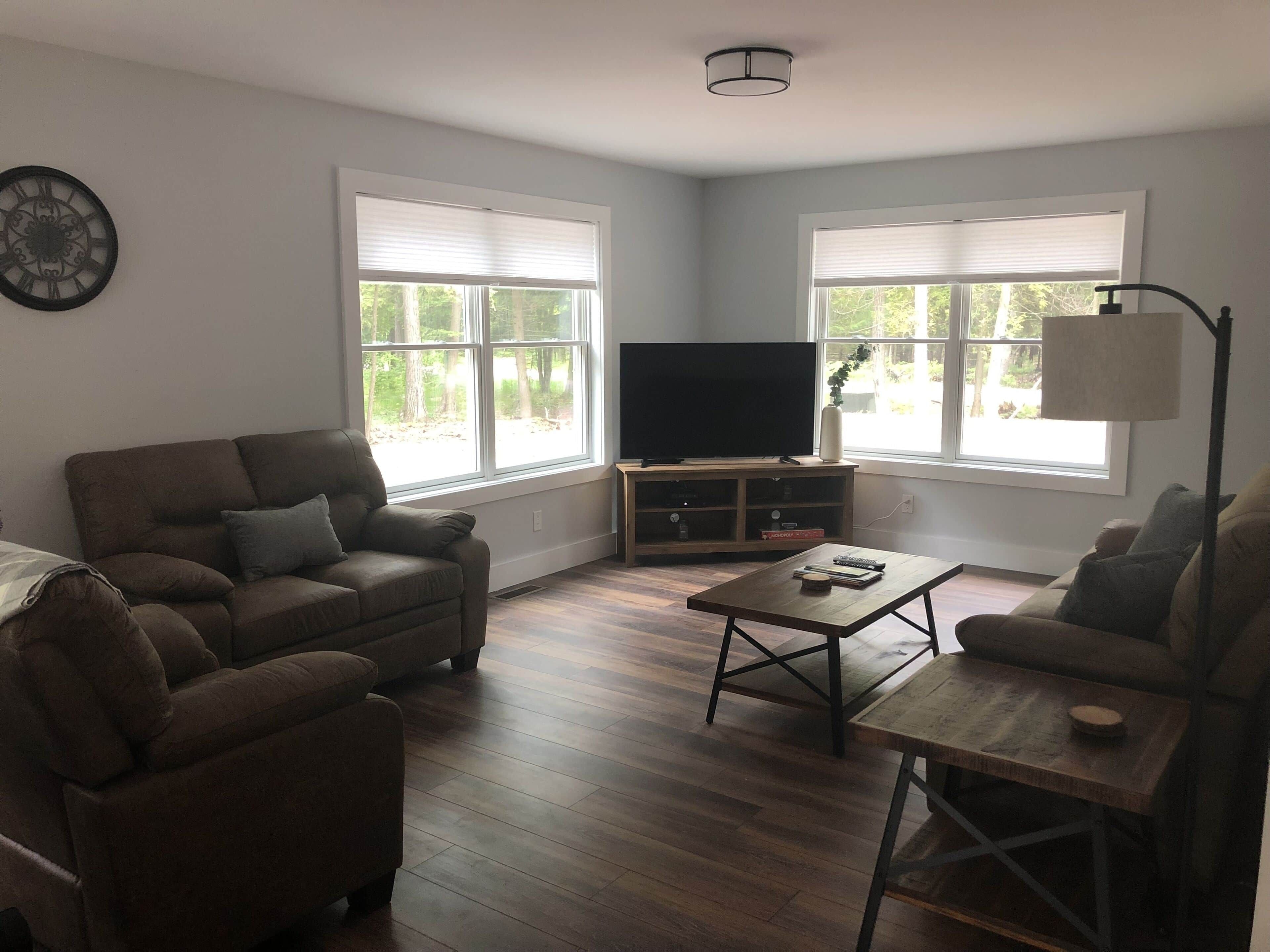A living room with a sofa, a coffee table, and a TV on a stand.